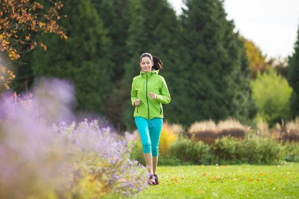 Junge brünette Frau läuft in Park. — Stockfoto