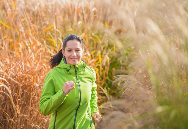 Young woman running and listening to music. — Stock Photo, Image