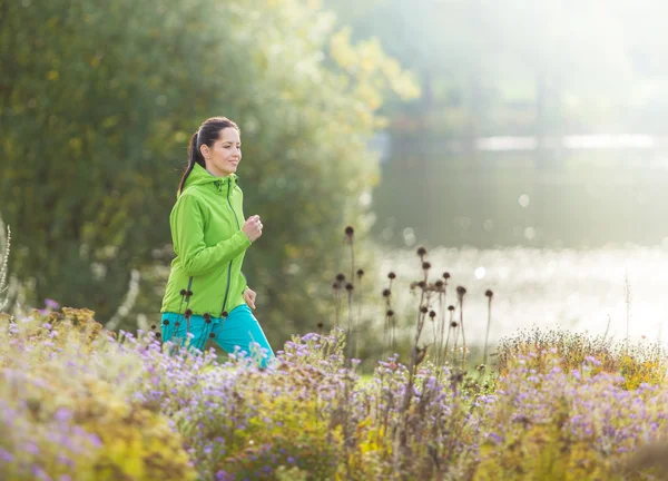 Junge brünette Frau läuft in Park. — Stockfoto