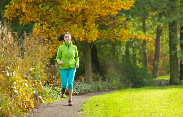 Junge brünette Frau läuft in Park. — Stockfoto