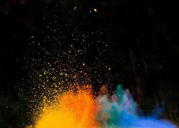 Launched colorful powder over black — Stock Photo, Image