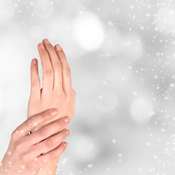 Vrouw de hand op Kerstmis achtergrond — Stockfoto