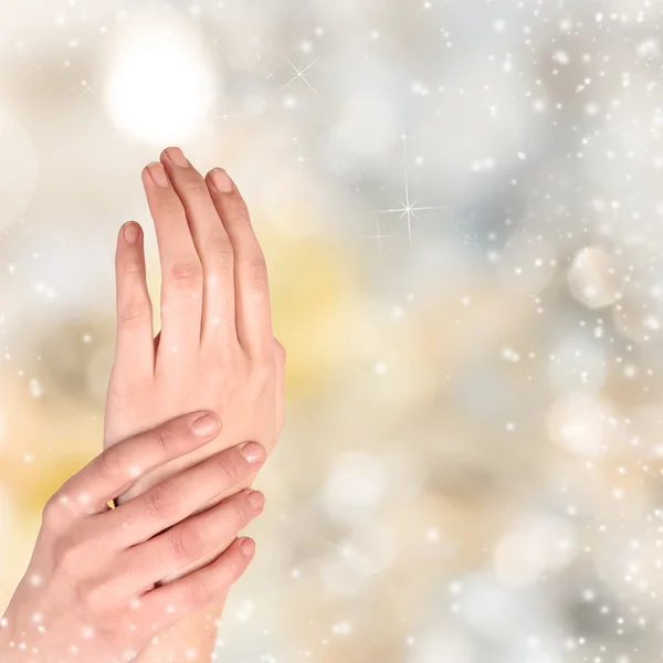 Frau Hand auf weihnachtlichem Hintergrund — Stockfoto