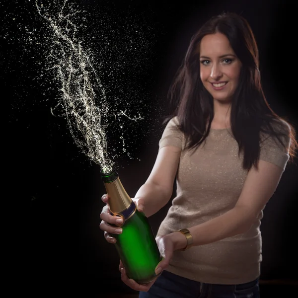 Junge brünette Frau mit Champagnerflasche — Stockfoto