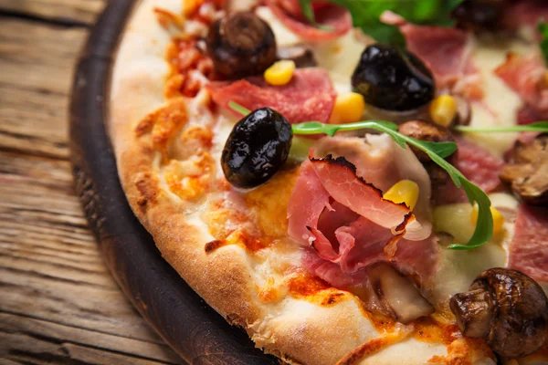 Deliciosa pizza italiana servida sobre mesa de madera — Foto de Stock