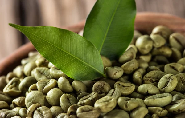 Green coffee beans in wooden bowl — Stock Photo, Image