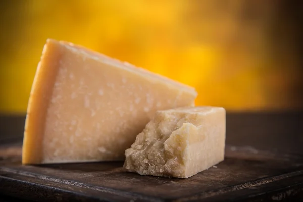 Parmigiano reggiano na dřevěné pozadí — Stock fotografie