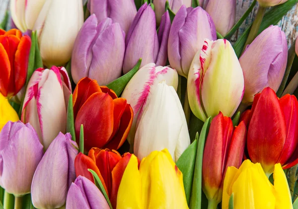 Belo buquê de tulipas na mesa de madeira . — Fotografia de Stock