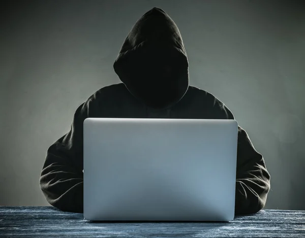 Hacker mit Kapuze und Laptop — Stockfoto