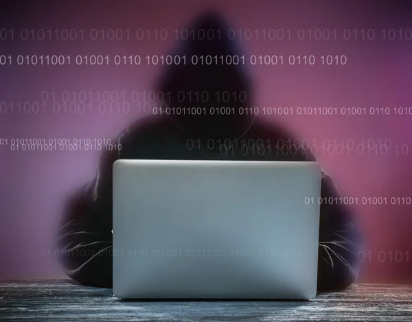 Un hacker avec une cagoule avec ordinateur portable — Photo