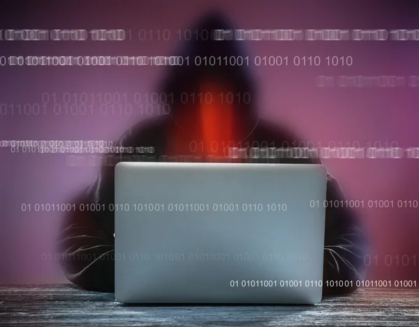 Хакер с капюшоном и ноутбуком — стоковое фото
