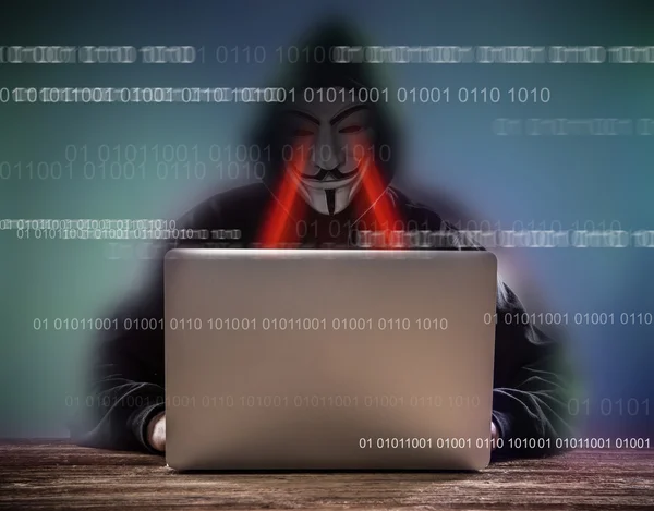 Ένας χάκερ με κουκούλα με laptop — Φωτογραφία Αρχείου