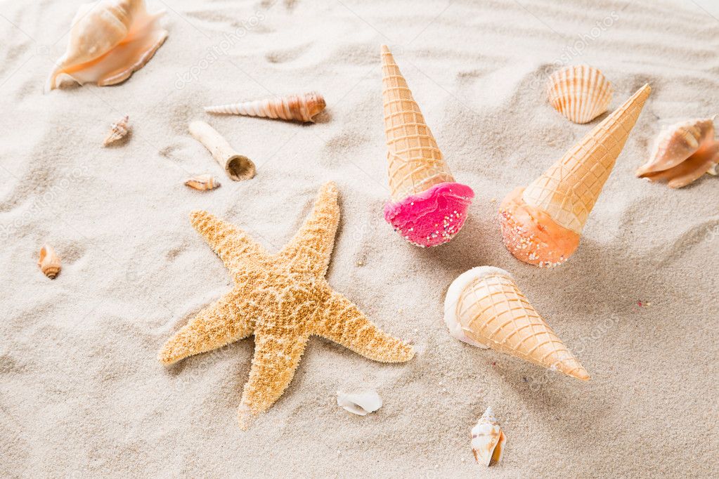 Ice cream scoops on sandy beach.