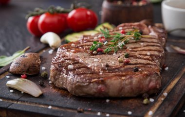 Beef rump steak on black stone table clipart