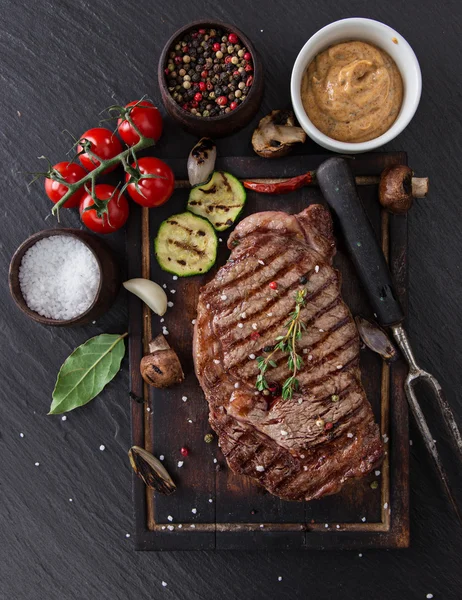 Bife de carne na mesa de pedra preta — Fotografia de Stock