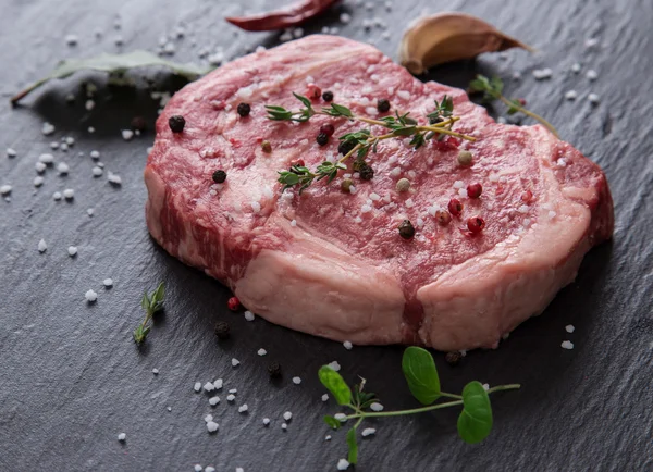 Raw beef steak onblack table — Stock Photo, Image