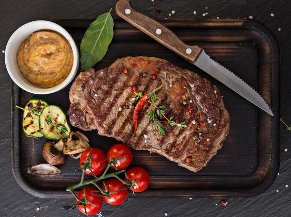 Carne de res chuletón en mesa de piedra negra —  Fotos de Stock