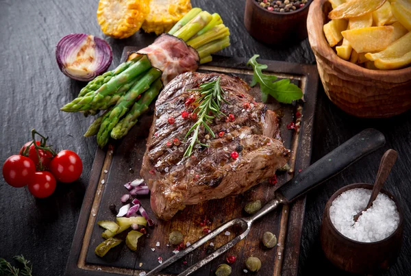 Bife de carne na mesa de pedra preta — Fotografia de Stock