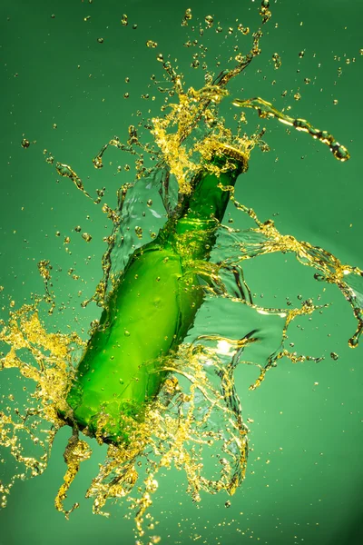 Bouteille de bière verte avec éclaboussures liquides — Photo