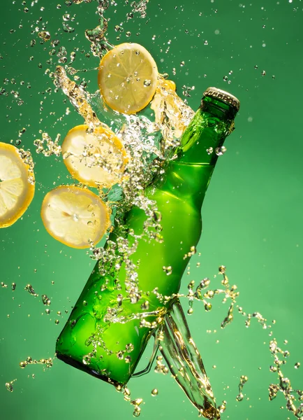 Bouteille de bière verte avec éclaboussures liquides — Photo