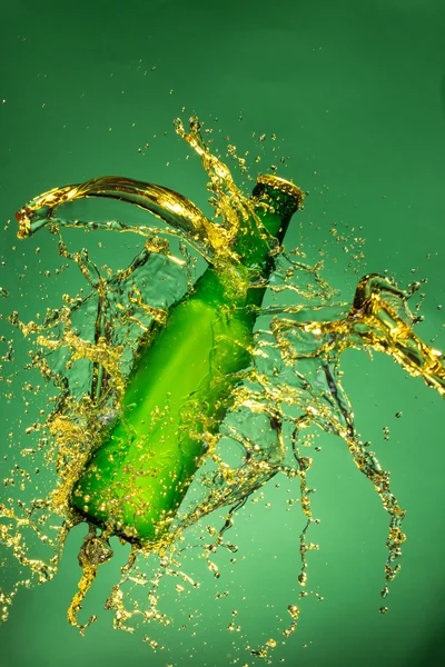 Зеленая бутылка пива с брызгами жидкости — стоковое фото