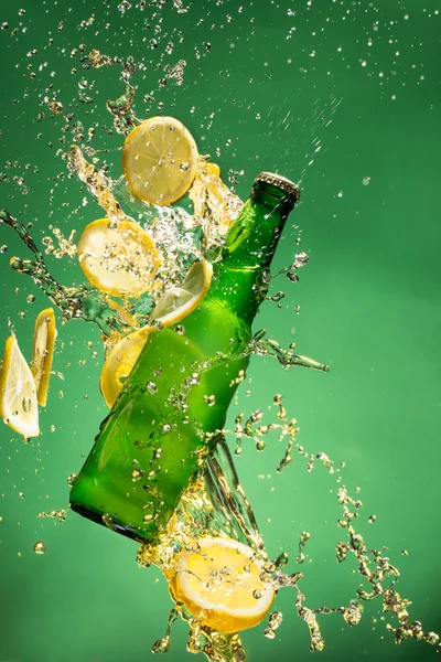 Зеленая бутылка пива с брызгами жидкости — стоковое фото