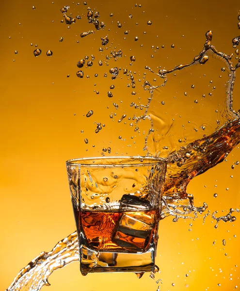 Whisky avec glace avec éclaboussures liquides — Photo