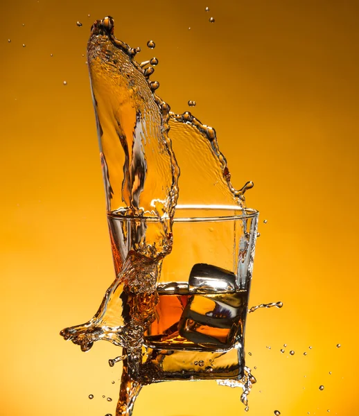 Whisky avec glace avec éclaboussures liquides — Photo