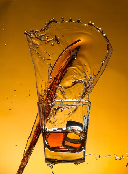 Whisky con ghiaccio con spruzzi di liquido — Foto Stock