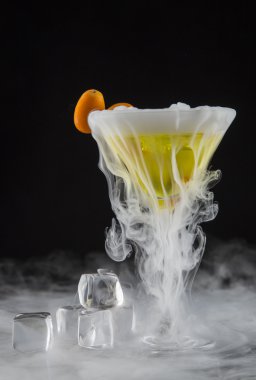 Bar masasında buz buharlı kokteyl.