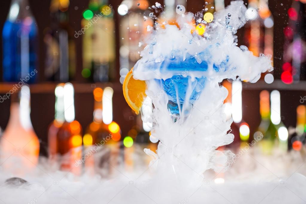 Cocktail with ice vapor on bar desk