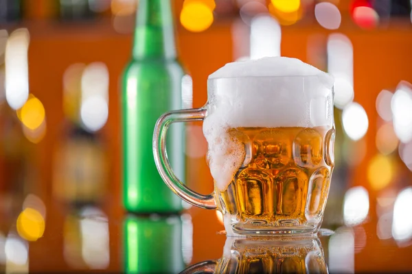 Garrafa de cerveja com vidro na mesa do bar — Fotografia de Stock