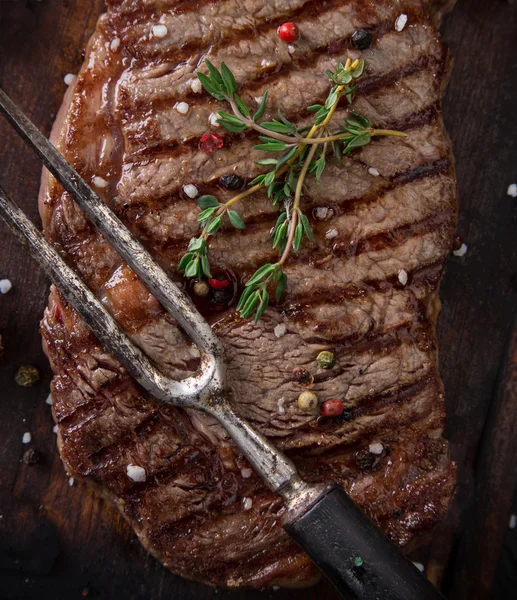 Beef steak on wooden table — Stock Photo, Image