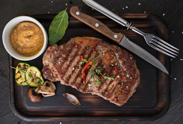 Beef steak on wooden table — Stock Photo, Image