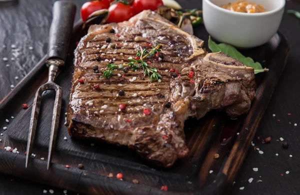 Hovězí steak na dřevěný stůl — Stock fotografie