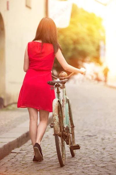 Menina morena bonita em uma bicicleta vintage — Fotografia de Stock