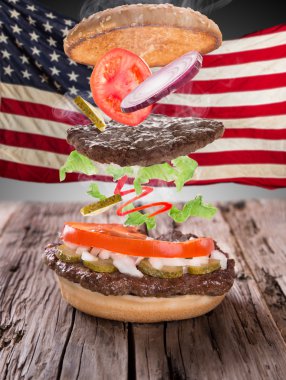 Yangın alevler ve Amerikan bayrağı ile lezzetli hamburger