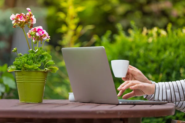 Las mujeres que trabajan con el ordenador portátil en el jardín —  Fotos de Stock