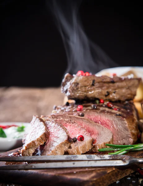 Delicioso bistec de res sobre mesa de madera —  Fotos de Stock