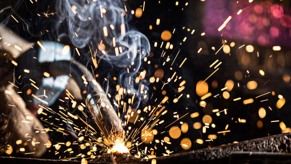 Welder in action with bright sparks.