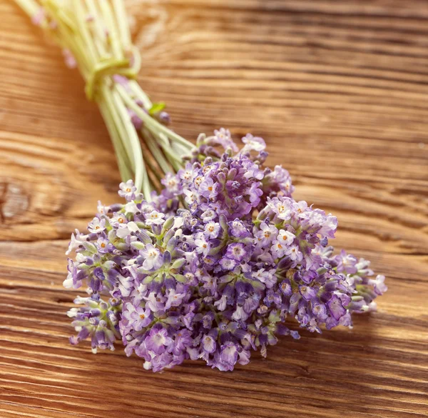 Tratamientos de bienestar con flores de lavanda sobre mesa de madera. — Foto de Stock