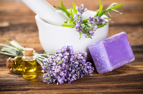 Wellness treatments with lavender flowers on wooden table. — Stock Photo, Image