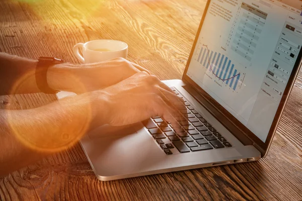 Akıllı telefon ve dizüstü kullanarak çalışan adam.