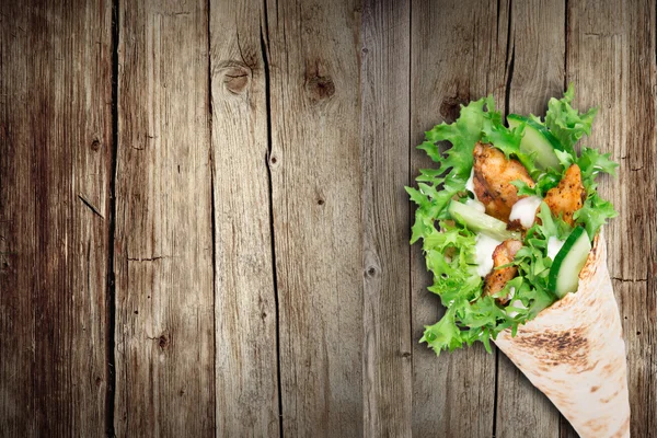 Tortilla kip wrap sandwich op houten achtergrond. — Stockfoto