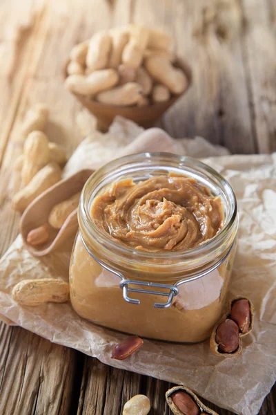 Jordnötssmör på trä bakgrund. — Stockfoto