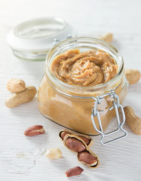 Peanut butter on wooden background. — Stock Photo, Image