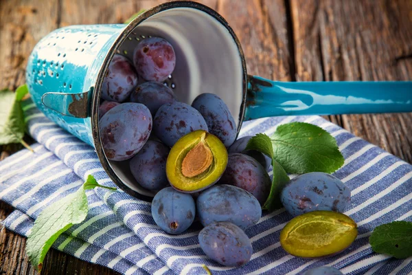 Fresh plums on old wooden table — Stock Photo, Image