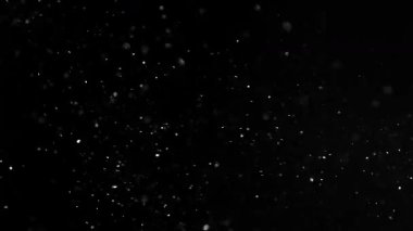 Siyah bir zeminde havada parçacıklar ve toz var. 1000 fps 'lik yüksek hızlı bir sinema kamerasında çekildi.