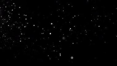 Siyah bir zeminde havada parçacıklar ve toz var. 1000 fps 'lik yüksek hızlı bir sinema kamerasında çekildi.