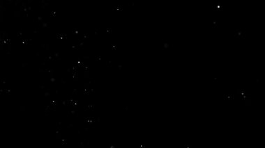 Siyah bir zeminde havada parçacıklar ve toz var. 1000 fps 'lik yüksek hızlı bir sinema kamerasında çekildi.